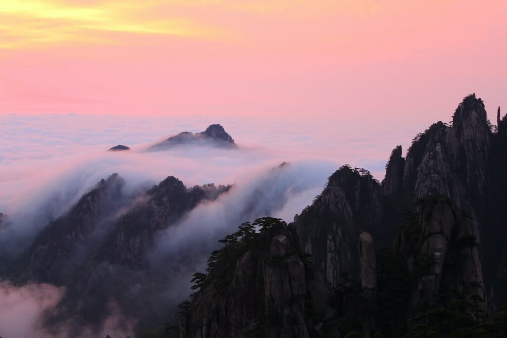 Majestic Huangshan Mountain at sunrise, adorned with clouds, revealing its breathtaking peak