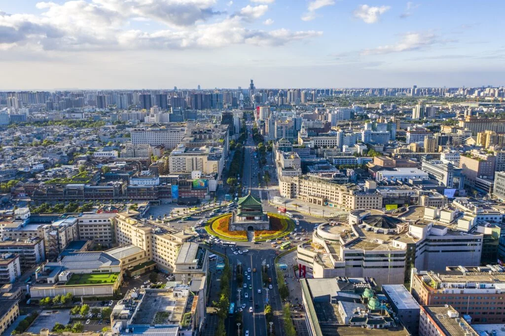 A mesmerizing aerial view of Xi'an city during the day, showcasing its vibrant skyline with numerous buildings and a bustling urban landscape