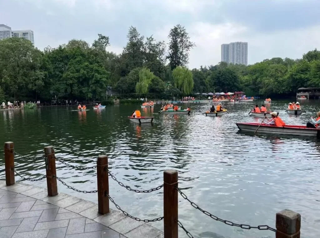 There are many boats on the lake with people enjoying the scenery