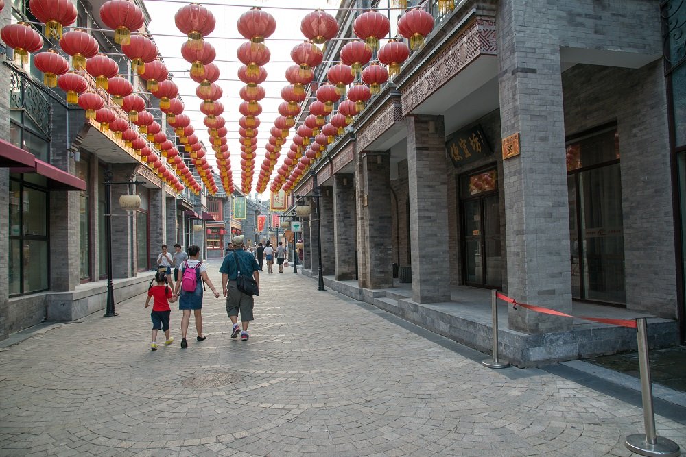 Pedestrians walk under a patchwork of red lanterns