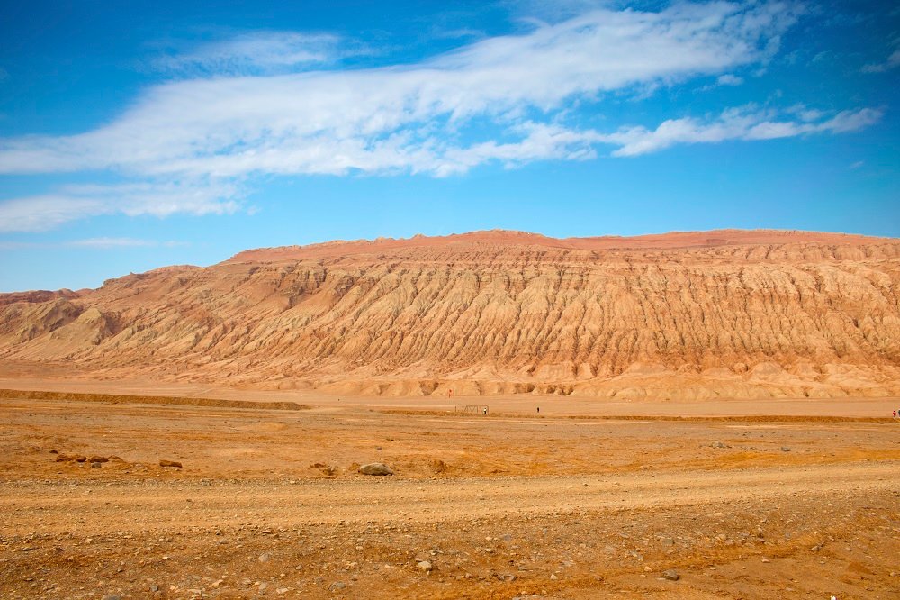 The Flaming Mountains Scenic Area primarily features striking reddish-brown sandstone landscapes