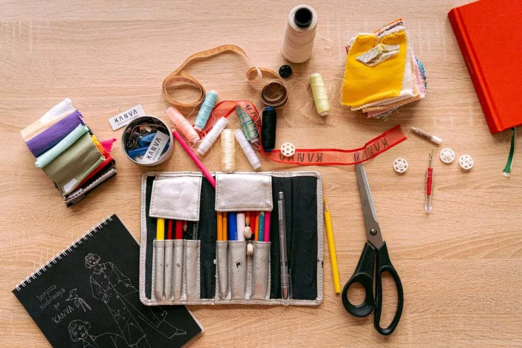 There are many embroidery and sewing tools on the table