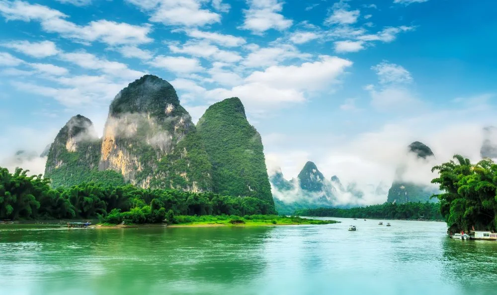 Serene Yulong River in Guilin, surrounded by iconic karst mountains reflecting in the water.