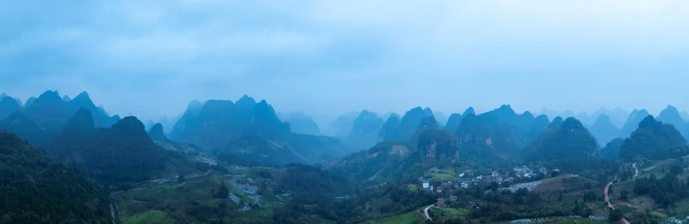 Aerial view of Xianggong Mountain showcasing the dramatic karst peaks, shrouded in soft light, creating a serene and captivating scene