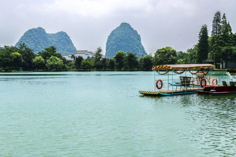 Bamboo rafting near Reed Flute Cave, Guilin, offering scenic views of the surrounding landscape