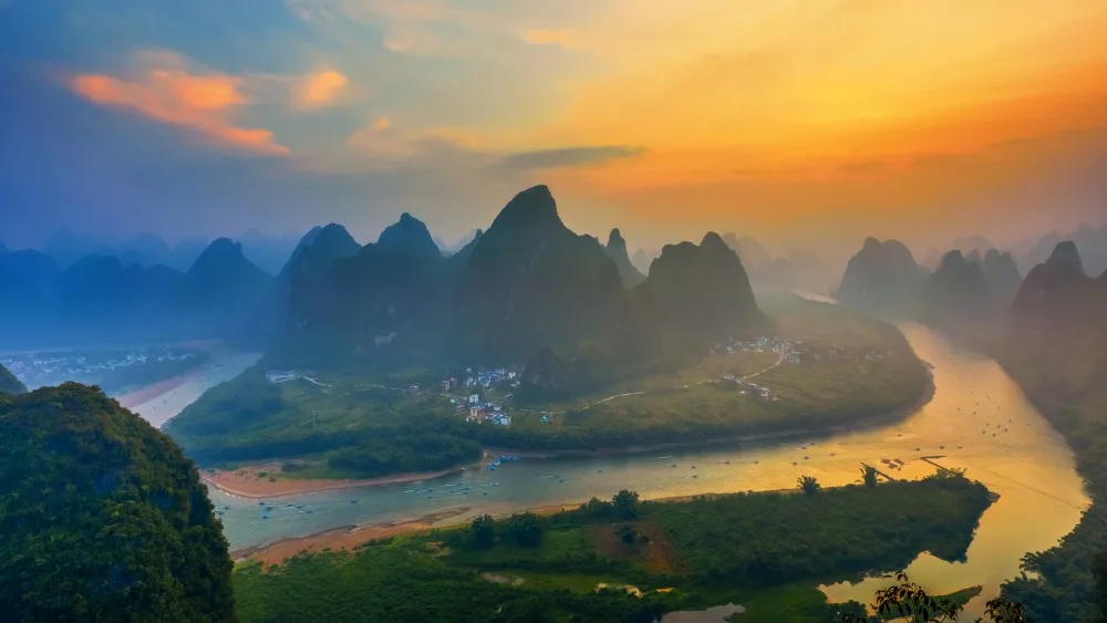 Breathtaking sunrise over Xianggong Mountain in Yangshuo, capturing the stunning beauty of the golden light illuminating the landscape
