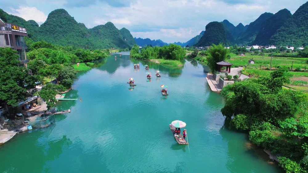 Scenic view near Reed Flute Cave, featuring bamboo rafting on the Yulong River in Guilin