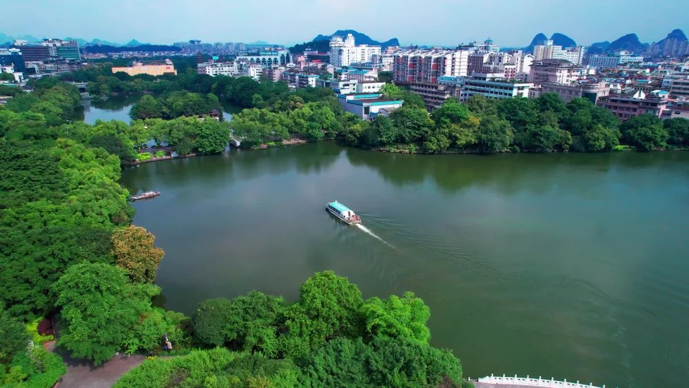 Tourists cruising on a boat, admiring the beauty of Two Rivers and Four Lakes